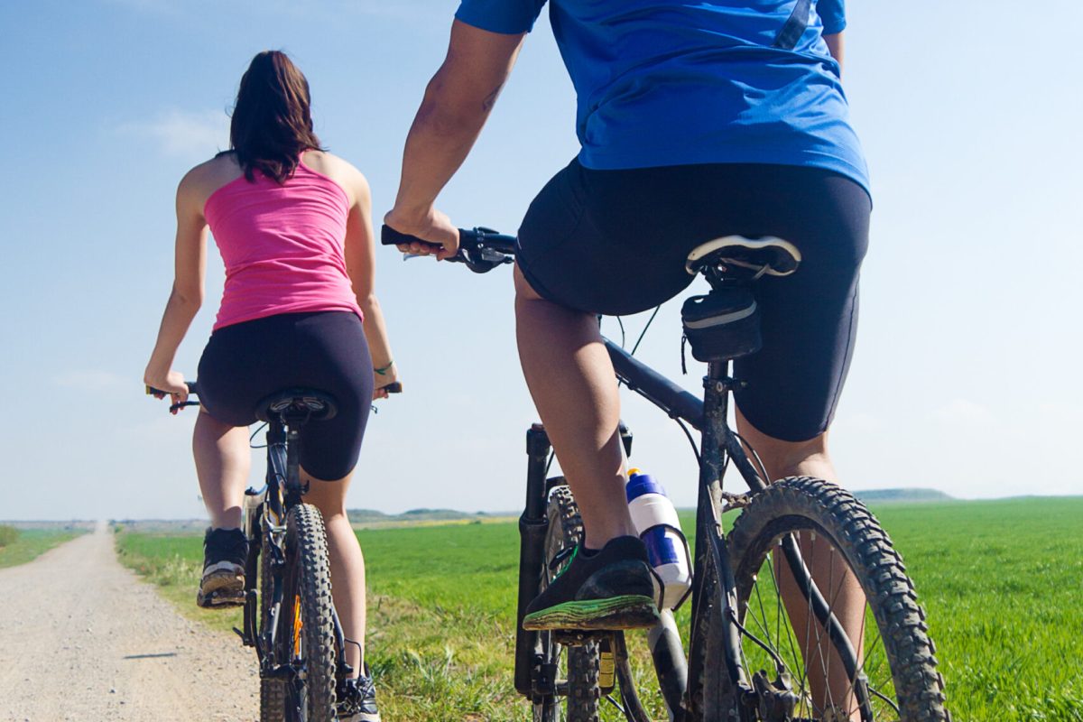 Spring portrait of  Happy young  couple on a bike ride in the countryside