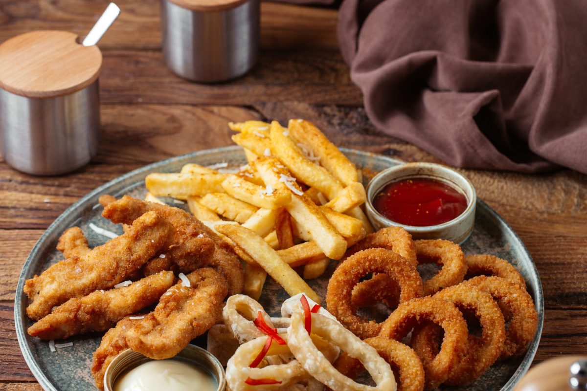 front-view-french-fries-with-fried-chicken-wings-onion-rings-with-ketchup-brown-wooden-desk-food-meal-potato