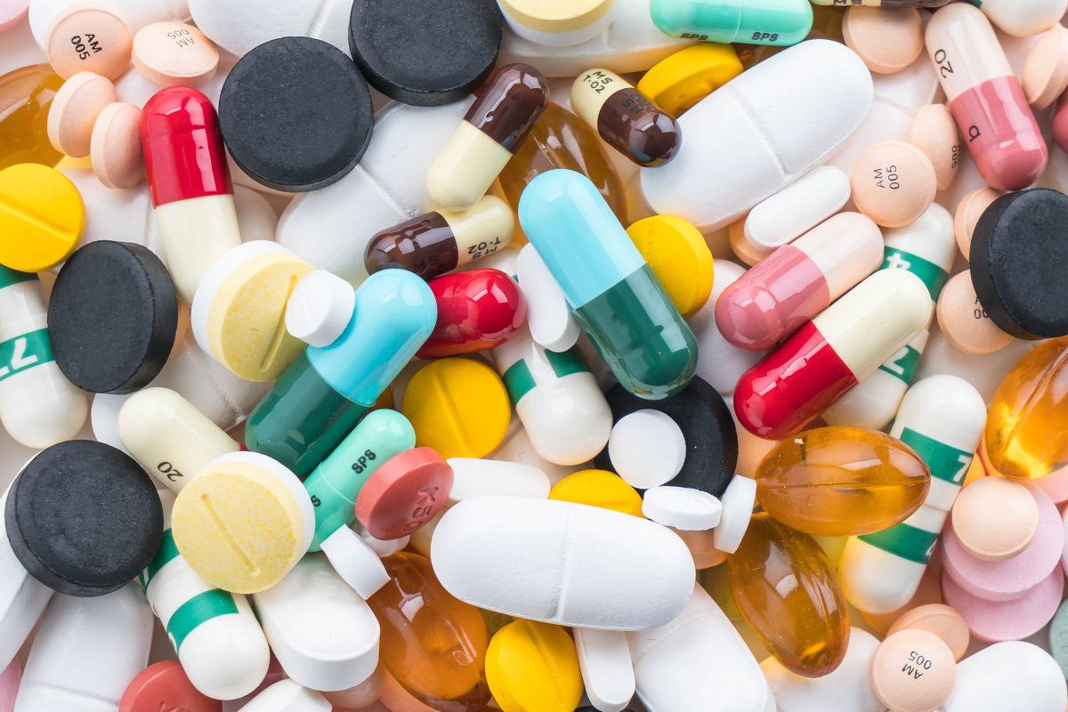 packings of pills and capsules of medicines on white background